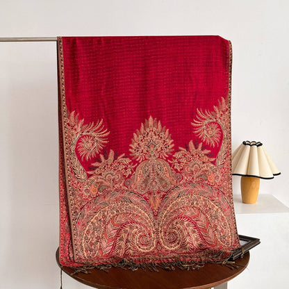 Red woven scarf with ornate gold floral and paisley motifs, a patterned border and fringe.