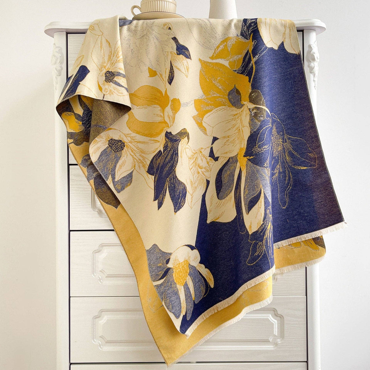 Navy and yellow floral scarf draped on dresser at Dover Grace Boutique in Watkinsville, Georgia.