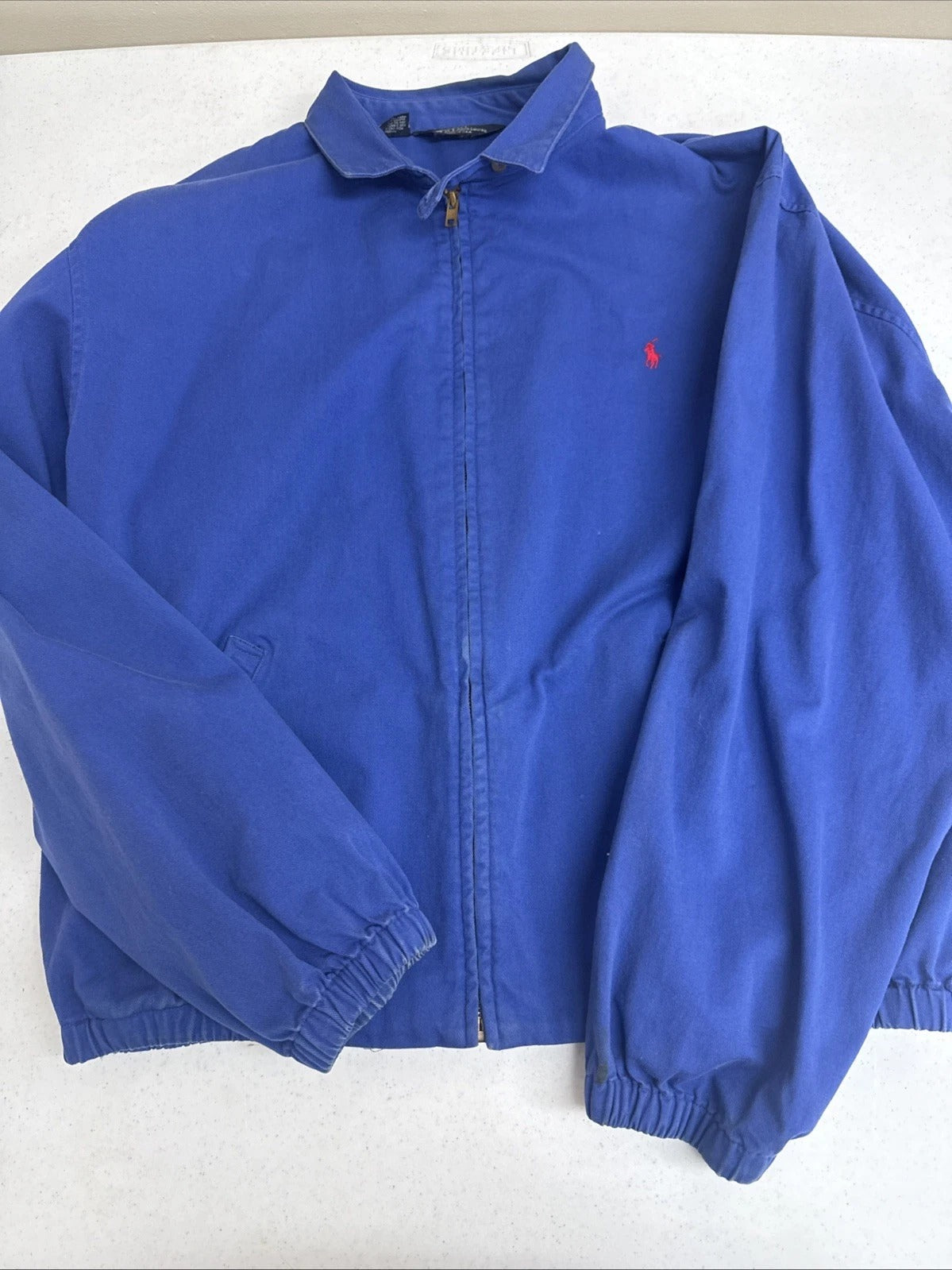 Blue jacket with a red logo on a white background