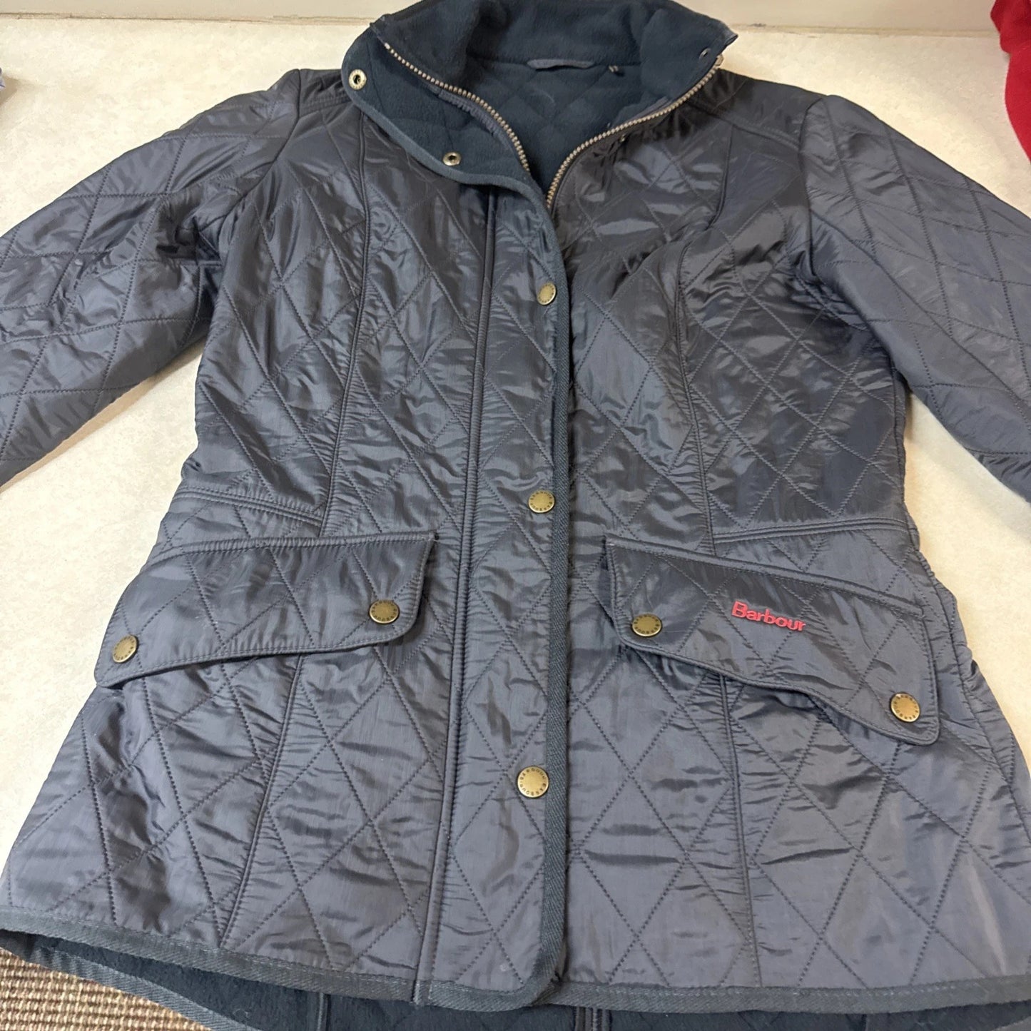 Gray quilted jacket with brand logo on a light background
