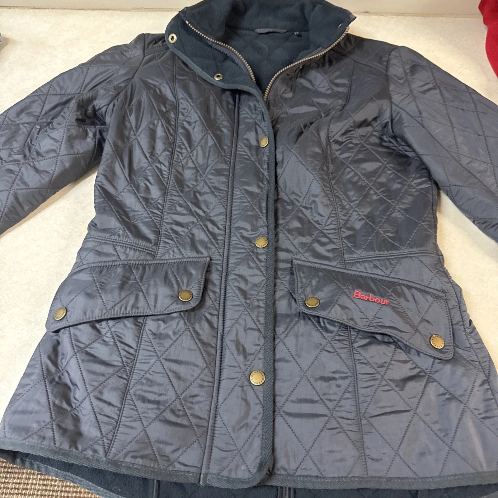 Gray quilted jacket with brand logo on a light background