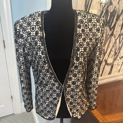 Black lace cardigan on a mannequin against a neutral background
