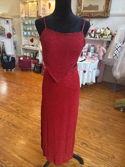 Red dress on a mannequin in a store setting with various items in the background.