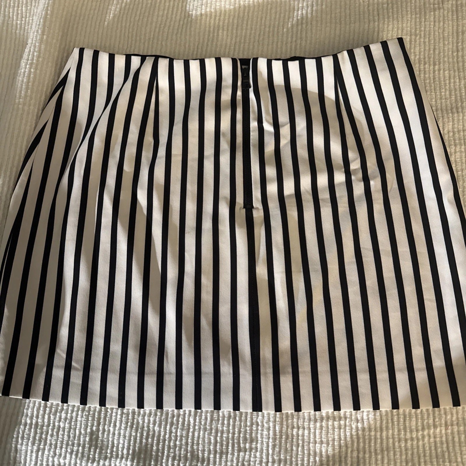 Black and white striped skirt on a textured surface