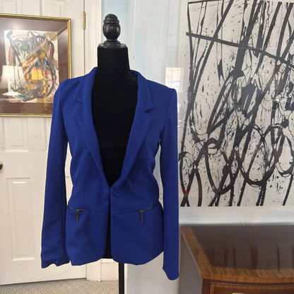 Blue blazer on a mannequin against a wall with abstract art