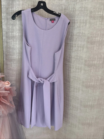 Lavender dress on a hanger against a textured wall