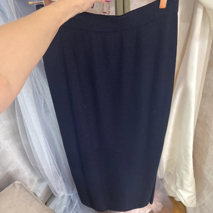 Navy blue skirt hanging on a rack with a blurred background