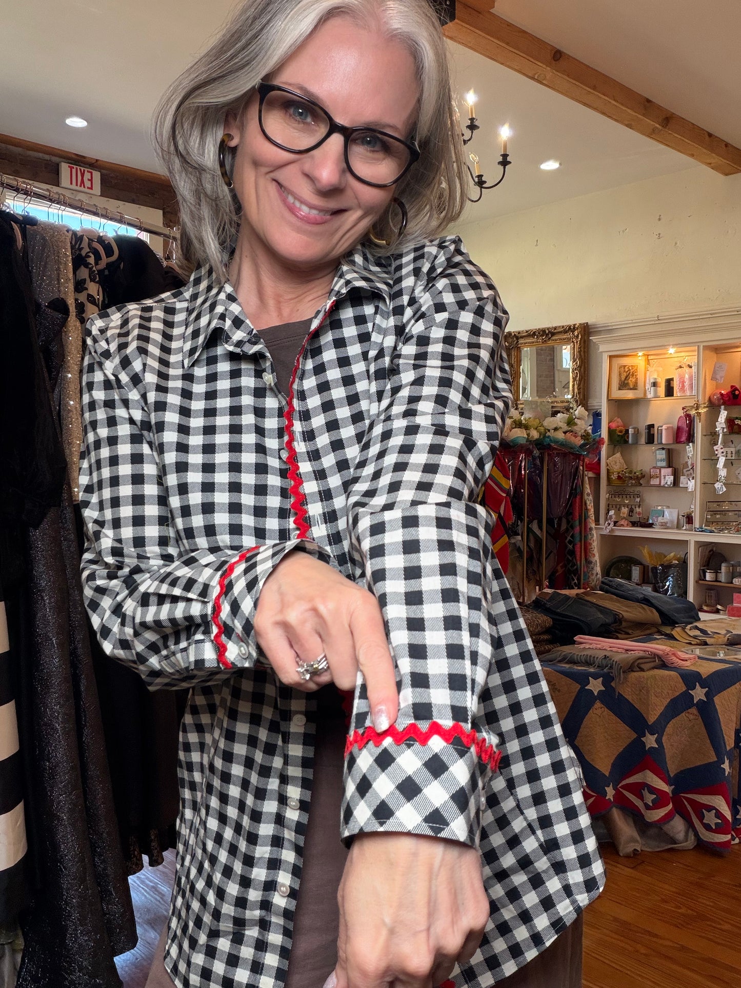 Close-up of a black and white gingham sleeve with red rickrack trim at the cuff.
