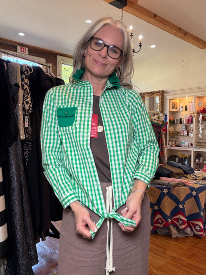 Green gingham shirt worn open over a taupe outfit as the front hem is tied.
