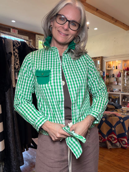 Green gingham button-up shirt with a ruffle collar, green flap pocket and tied front hem.