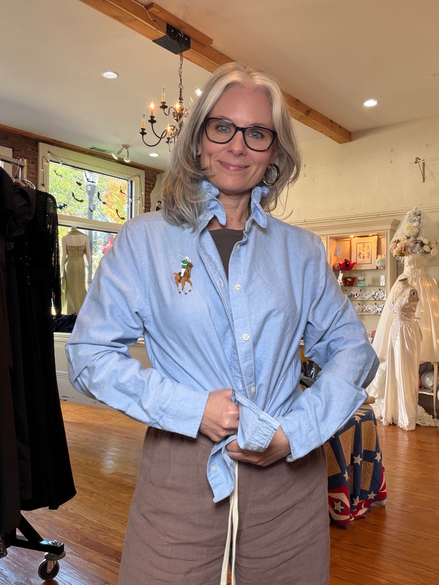 Model wearing the upcycled Ralph Lauren light blue oxford shirt with the front tied at the waist